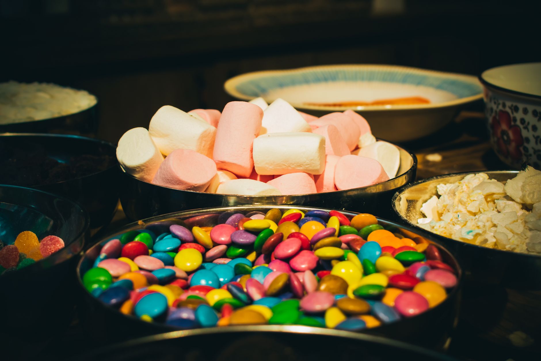 Une présentation vibrante de guimauves, bonbons et friandises dans des bols. Parfait pour des thèmes de célébration.